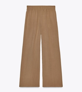 Detail view of the elastic waistband and textured cotton linen fabric on brown wide-leg pants