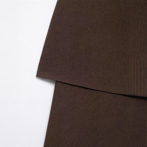 Gros plan d'une robe bustier marron foncé montrant le tissu sergé et les lignes géométriques