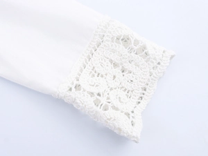 Close-up of white cotton shirt cuff with intricate floral crochet lace and scalloped edge