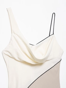 Detail of asymmetrical neckline with contrast piping and draped patchwork fabric