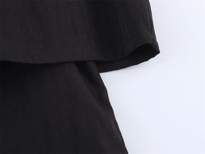 Detailed close-up of double-stitched hem on high-quality black short sleeve shirt fabric