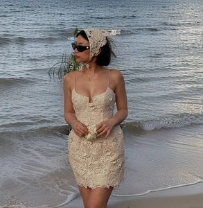 Detailansicht des beigen Spitzenkleides und Kopftuchs für einen eleganten Strandurlaub