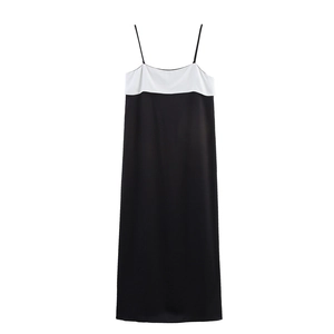 Dettaglio dell'abito sottoveste in raso bianco e nero con texture liscia e spalline sottili