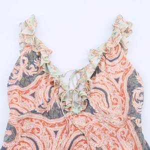Dettaglio del vestito bohémien con stampa paisley, scollo a V e lacci con volant