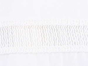 Macro shot of delicate white crochet lace trim on breathable cotton linen fabric