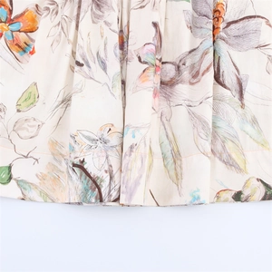 Detailed macro view of floral and butterfly print fabric with orange hem stitching