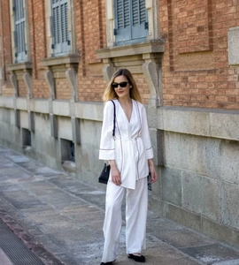 Detail of white cotton linen two-piece set featuring contrast piping and wide leg trousers