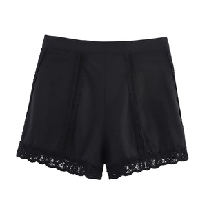 Detail of high-waisted black shorts with crochet lace trim and vertical stitching