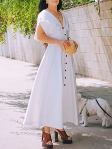 Detail of white short sleeve dress with contrast black buttons and elegant V-neck design