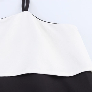 Dettaglio dello scollo dell'abito in raso a contrasto bianco e nero con spalline