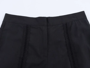 Detailed close-up of black shorts waist with crochet lace trim and invisible fly detail
