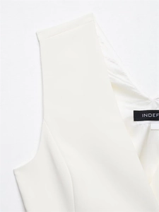 Detail of V-neck sleeveless white top with INDEF brand label and smooth fabric texture