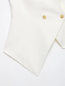Detailed close-up of white asymmetric vest hem with tortoiseshell buttons and texture