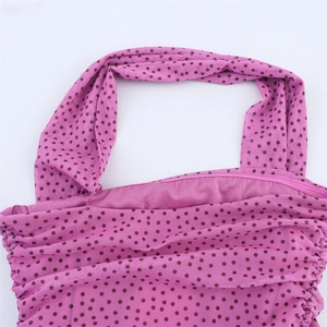 Dettaglio del tessuto in rete rosa a pois con arricciature e design a girocollo
