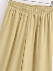 Detail of high-waist elastic waistband and textured cotton linen fabric on khaki wide-leg pants