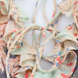 Dettaglio della stampa floreale paisley su abito in chiffon con balze e lacci sottili