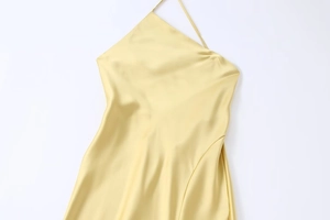 Détail du tissu en satin de soie jaune pâle avec drapé élégant et texture lisse