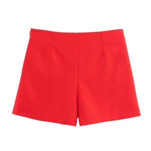 Detail view of red high-waisted shorts with smooth fabric and side invisible zipper