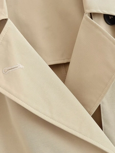Detail of khaki trench coat collar with stitching and high-quality resin button detail