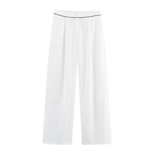 Detail view of white wide-leg trousers featuring black piping and pleated front design
