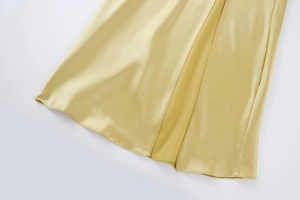 Détail du tissu satiné champagne montrant la texture soyeuse et l'ourlet lisse de la robe