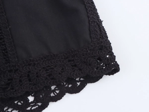 Close-up of black shirt with intricate crochet lace detailing and bohemian stitching