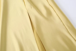 Détail d'une robe en satin champagne montrant la texture soie et la fente latérale