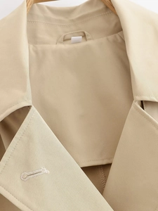 Detail of khaki jacket lapel and shoulder showing premium twill fabric texture