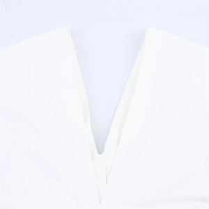 Close-up of sleek deep V-neckline on a minimalist white solid color dress