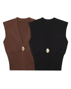 Detail of V-neck knitted vest showing fine texture and irregular gold lava button