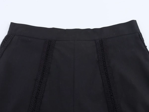 Detailed close-up of intricate hollow crochet lace edging on black high-waisted shorts