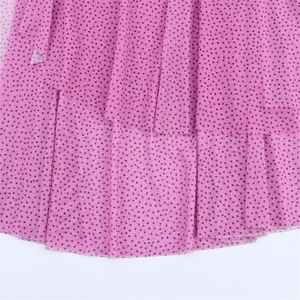 Dettaglio dell'abito in chiffon rosa a pois neri con orlo a balze a doppio strato sottile
