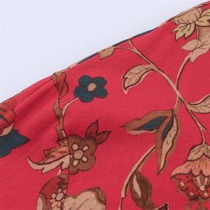Close-up of vintage floral print fabric with red blossoms and fine stitching details