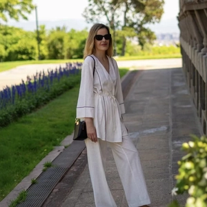 Women's white two-piece lounge set with black contrast piping and wide-leg pants