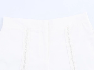 Detailed close-up of white shorts featuring intricate hollow crochet lace waistband patterns