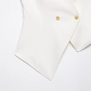 Minimalist white asymmetric vest with two amber buttons and a sharp tailored hem design
