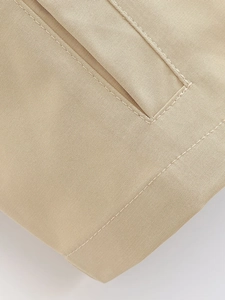 Detailed close-up of khaki twill fabric featuring reinforced double-stitch sewing