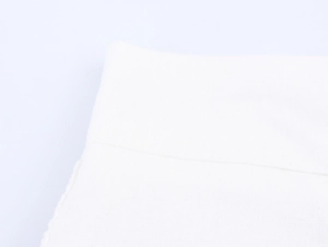 Detailed close-up of white crochet fabric texture and fine stitching on the shorts set