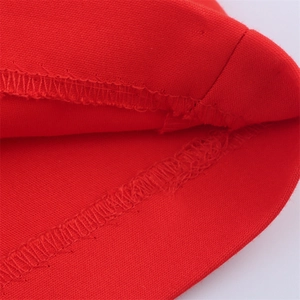 Detailed close-up of high-waisted red fabric with neat overlock stitching and texture