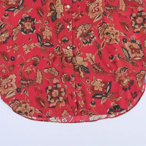 Detail of red floral print blouse showing white buttons and curved hemline finish