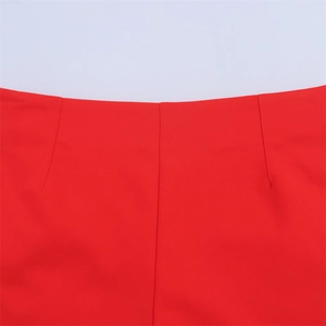 Detail view of high waist red shorts showing precision dart stitching and smooth woven fabric