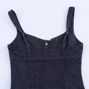 Detail of dark blue denim midi dress with adjustable straps and silver metal button