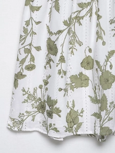 Dettaglio dell'abito in cotone bianco con stampa floreale e pizzo sangallo