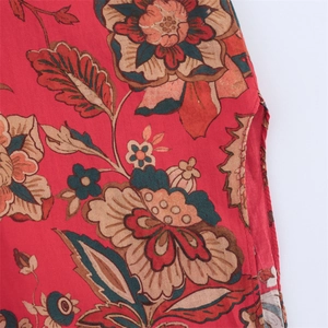 Detail of red floral print fabric with side slit design on long shirt for women