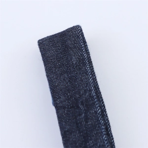 Macro view of dark blue denim twill weave strap with precise stitching detail