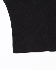Close-up of black ribbed knit fabric detail showing elastic texture and stitching