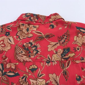 Detail of vintage floral pattern on red long blouse showing print and seam quality