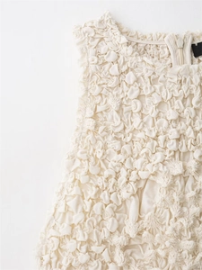 Detailed view of the textured off-white fabric and hidden zipper on the dress neckline