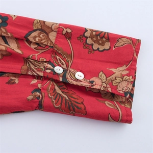 Detail of red floral print blouse sleeve with refined white button cuff closures