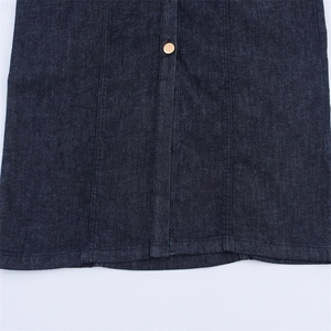 Detail of a dark indigo denim midi dress featuring premium stitching and a gold button